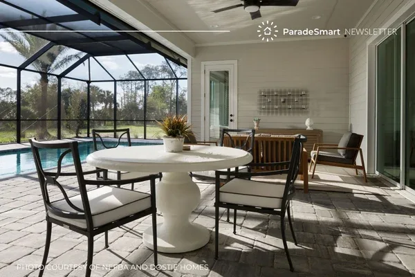 A screened outdoor patio with a round pedestal table, black metal chairs, and a pool in the background